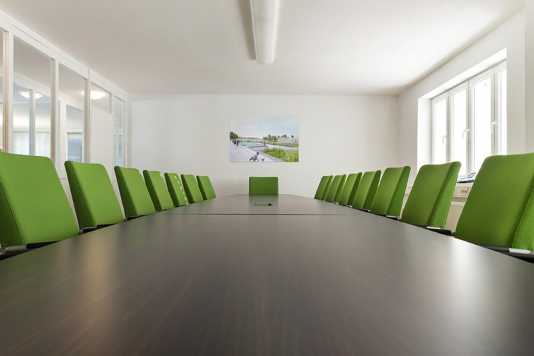 Konferenztisch mit grünen Stühlen